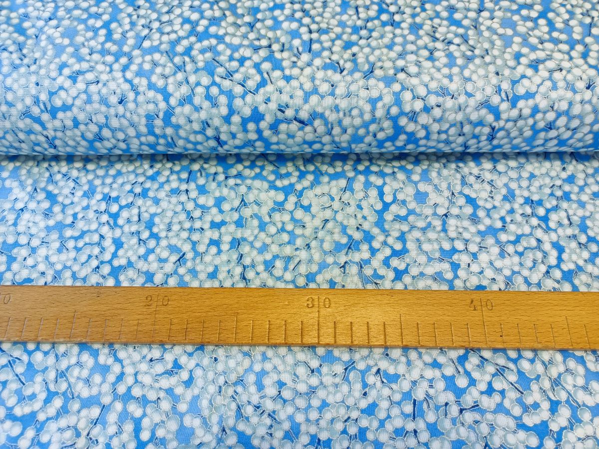 Bílostříbrné bobulky na větvičkách na světle modré