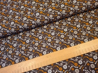 Béžovooranžové kvítky na tmavě hnědé